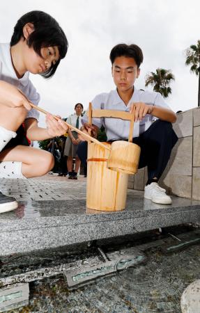 　平和公園の「平和の泉」から献水用の水をくむ生徒ら＝８日午前、長崎市