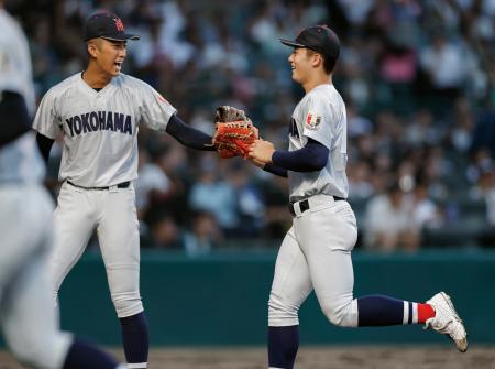 　横浜―敦賀気比　５回表、好返球で失点を防ぎ織田（左）とタッチを交わす横浜・奥村頼＝甲子園