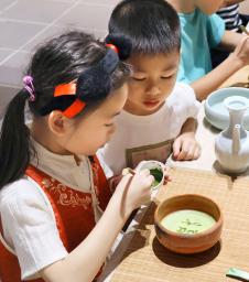 　抹茶の体験施設「抹香集」で抹茶に文字を書く子ども＝６月、中国貴州省銅仁市（共同）