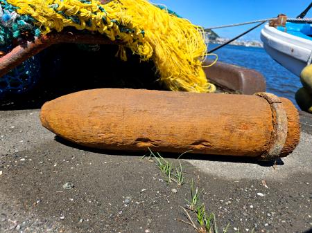 　北海道・稚内港の沖合でナマコ漁の漁船が引き揚げた、砲弾のような形の物＝１２日午前（稚内海上保安部提供）