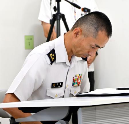 　市民団体のメンバーに頭を下げ、謝罪する陸自宮古島駐屯地トップの比嘉隼人１等陸佐＝１９日午後、沖縄県宮古島市