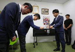 　読売新聞東京本社の幹部に抗議文を手渡す日本維新の会の池下卓衆院議員（中央右）＝２７日午後、大阪府高槻市