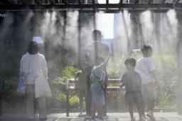 　東京・銀座でミストシャワーを浴びる人たち＝３１日午後