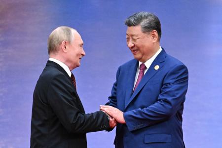 　上海協力機構首脳会議の式典で握手する中国の習近平国家主席（右）と、ロシアのプーチン大統領＝３１日、中国天津市（タス＝共同）