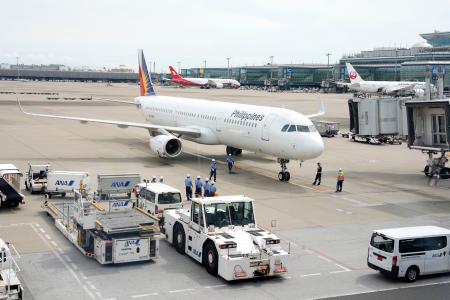 　羽田空港に到着した、フィリピンで殺害された日本人２人の遺体を乗せた民間機＝３日午後