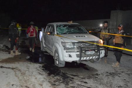 　自爆テロの現場で破損した車両を調べる保安当局者ら＝２日、パキスタン南西部クエッタ（ＡＰ＝共同）