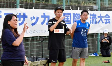 　交流キャンプで手話を使いコミュニケーションを取るデフサッカー男子日本代表元監督の植松隼人さん（中央）＝８月、東京都品川区