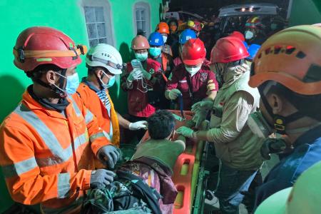 1日、インドネシア・シドアルジョで、倒壊したイスラム寄宿学校の建物で救助活動をする救急隊員(国家捜索救助庁提供・ゲッティ=共同)