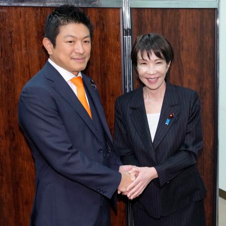 新執行部発足を受けたあいさつ回りで、参政党の神谷代表(左)と握手する自民党の高市総裁=8日午後、国会