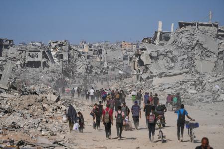 破壊された建物の間を歩く人たち。イスラエルとイスラム組織ハマスの停戦が発効した=10日、ガザ北部ガザ市(AP=共同)