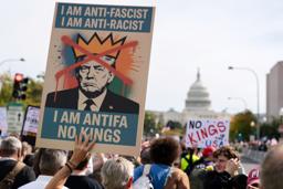 　トランプ大統領の政治手法に抗議するデモで「ＮＯ　ＫＩＮＧＳ（王はいらない）」を掲げる参加者＝１８日、ニューヨーク（ロイター＝共同）