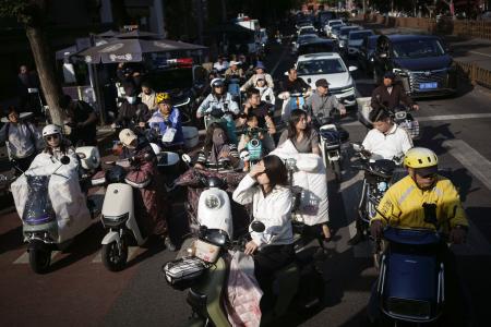 　北京市内の道路で信号を待つ人たち＝９月（共同）
