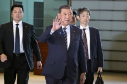 　花束を手に記者団の取材に応じる石破茂首相＝２１日午後０時２９分、首相官邸