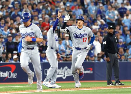ブルージェイズ戦の7回、2ランを放ち三塁コーチとタッチを交わすドジャース・大谷(右)=トロント(共同)