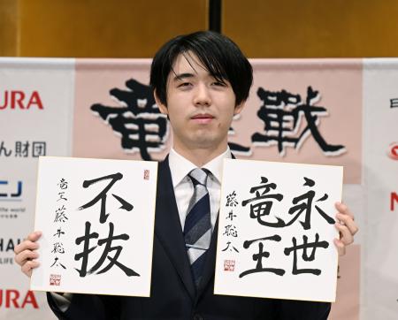 　竜王戦５連覇から一夜明け、色紙を手に写真に納まる藤井聡太竜王＝１４日午前、京都市下京区