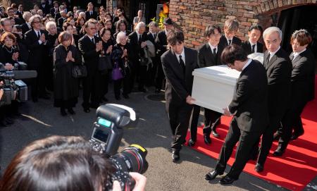 　出棺のため関係者に運ばれる仲代達矢さんのひつぎ。参列する役所広司さん（左奥）の姿もあった＝１４日午後、東京都世田谷区