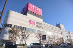 　クマの侵入を受け、休業のお知らせを張る「イオン能代店」の関係者＝１６日午後２時５８分、秋田県能代市