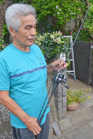 巨大クエを釣り上げたさおを持つ山内省二さん