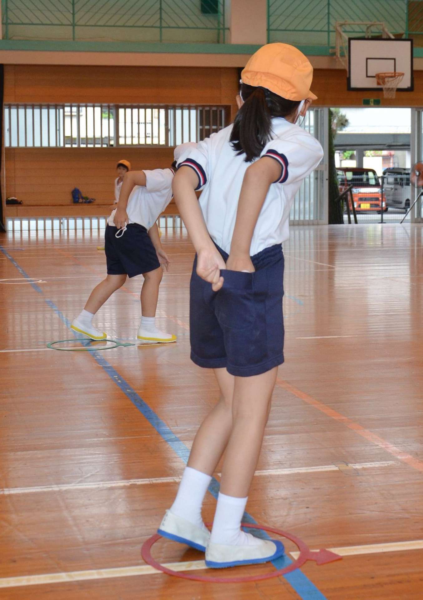 外したマスクを折り畳んで、ポケットにしまい込んでから走り出す練習をする児童＝鹿児島市の松原小学校