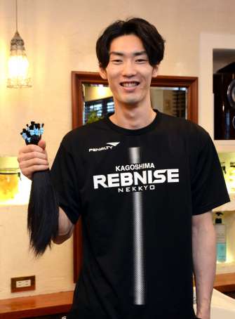 「手入れが楽になる」とカットした髪を手にする藤田浩司選手