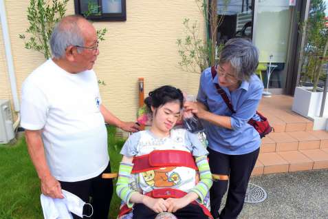 田中茜さん（中央）にカットした髪を見せる絹子さん（右）と洋海さん
