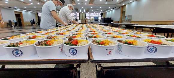 鶏飯を準備する関係者＝サンパウロ市のイベント会場（ブラジル鹿児島県人会提供）