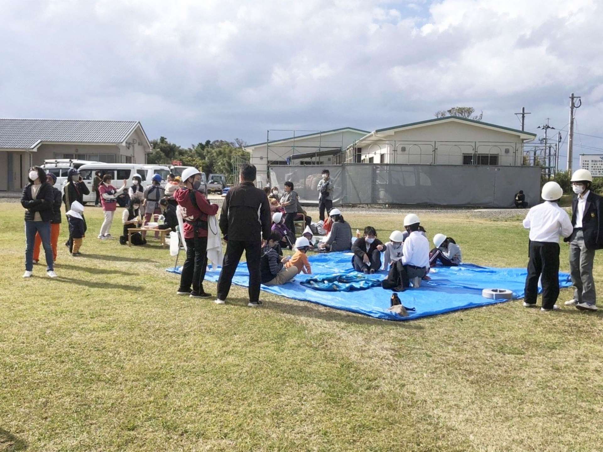 ヘルメットをかぶって校庭に避難する悪石島小中学校の児童生徒や島民ら＝９日午前１１時５０分ごろ、十島村悪石島の悪石島小中学校（住民提供）