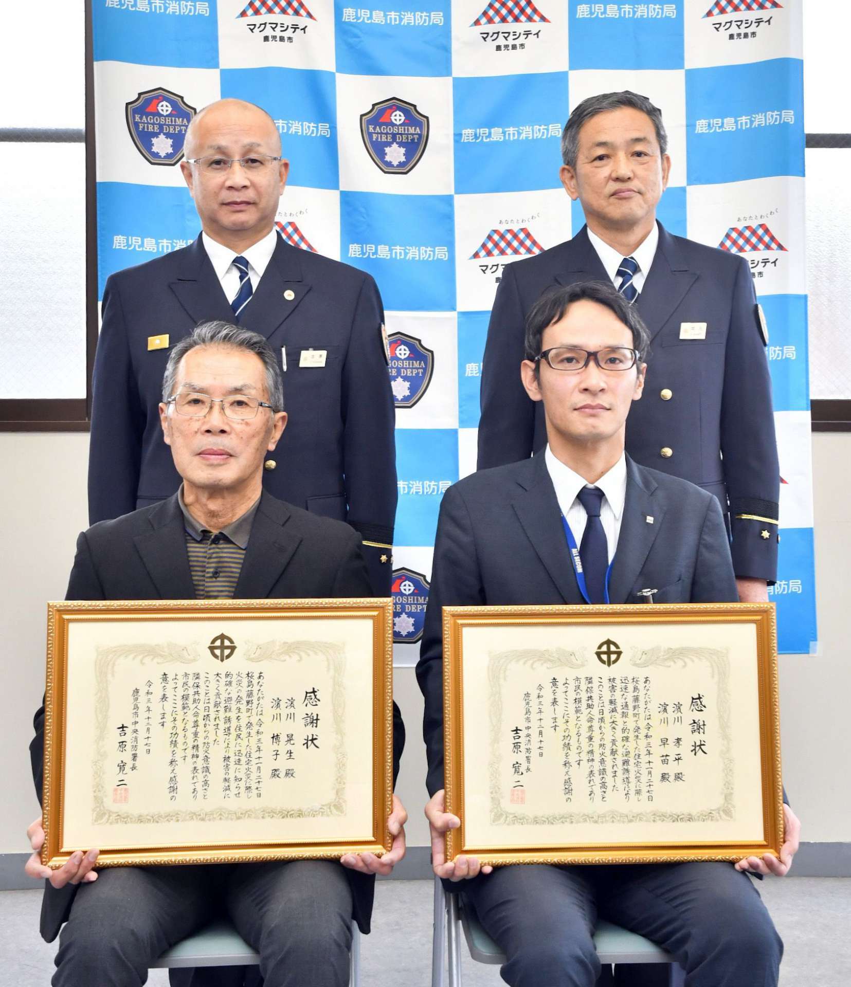 感謝状を手にする浜川晃生さん（左手前）と次男の孝平さん＝鹿児島市桜島藤野町