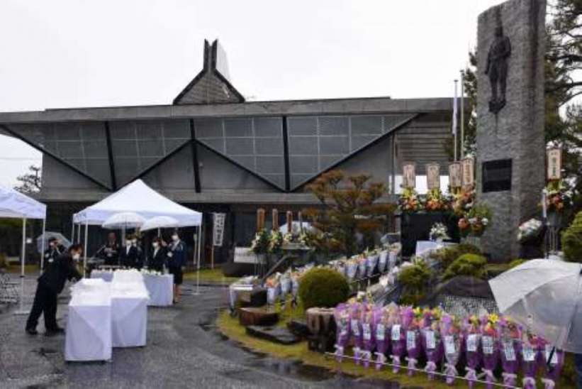 旧陸軍万世飛行場跡に建つ万世特攻平和祈念館。2020年4月に開かれた慰霊祭で、慰霊碑に献花する参列者＝南さつま市加世田高橋