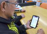 スマートフォンで牛の体温変化を確認する中山高司社長＝２月２７日、鹿屋市串良