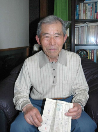 引き揚げ証明書を手に、当時の惨状を語る森一さん＝薩摩川内市入来町浦之名