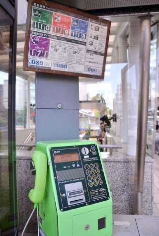 ＪＲ鹿児島中央駅の駅前広場にある公衆電話。かけ方を説明するパネルがある＝鹿児島市中央町