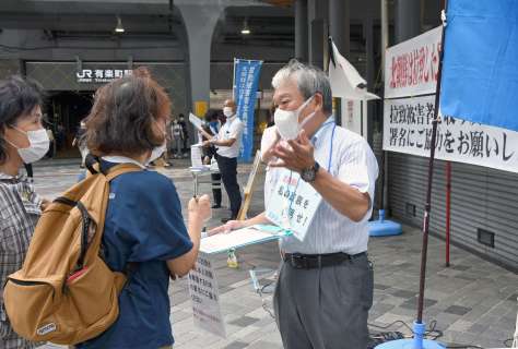 署名に協力を呼びかける増元照明さん（中央）＝１２日、東京・ＪＲ有楽町駅前