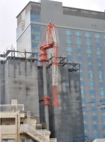 折れ曲がったマンション建設現場の作業用クレーン＝１８日午後３時半、鹿児島市高麗町