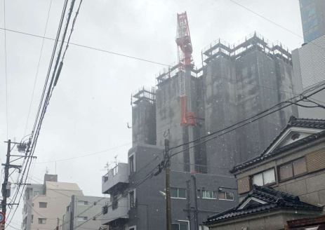 クレーンが折れ曲がり、近隣住民に避難を呼び掛ける警察官ら＝１８日午後２時４０分ごろ、鹿児島市高麗町