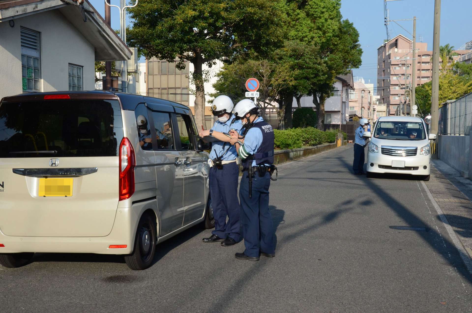 時間帯通行禁止の通学路に進入してきた車両を取り締まる鹿児島中央警察署員＝９月３０日、鹿児島市（画像は一部加工しています）