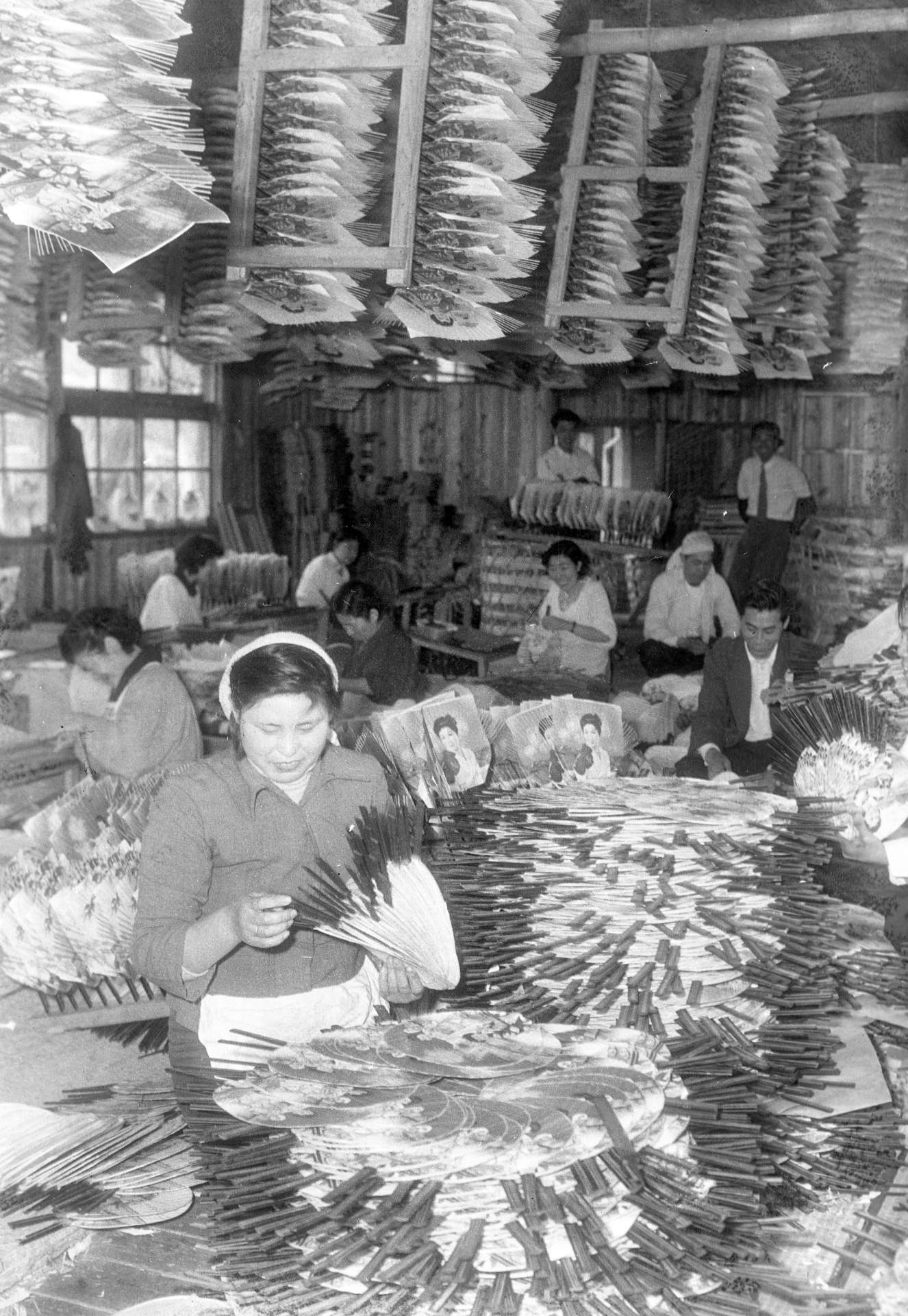 鹿児島市新屋敷町の鹿児島市営授産場のうちわ作りの風景＝１９５５（昭和３０）年３月２６日