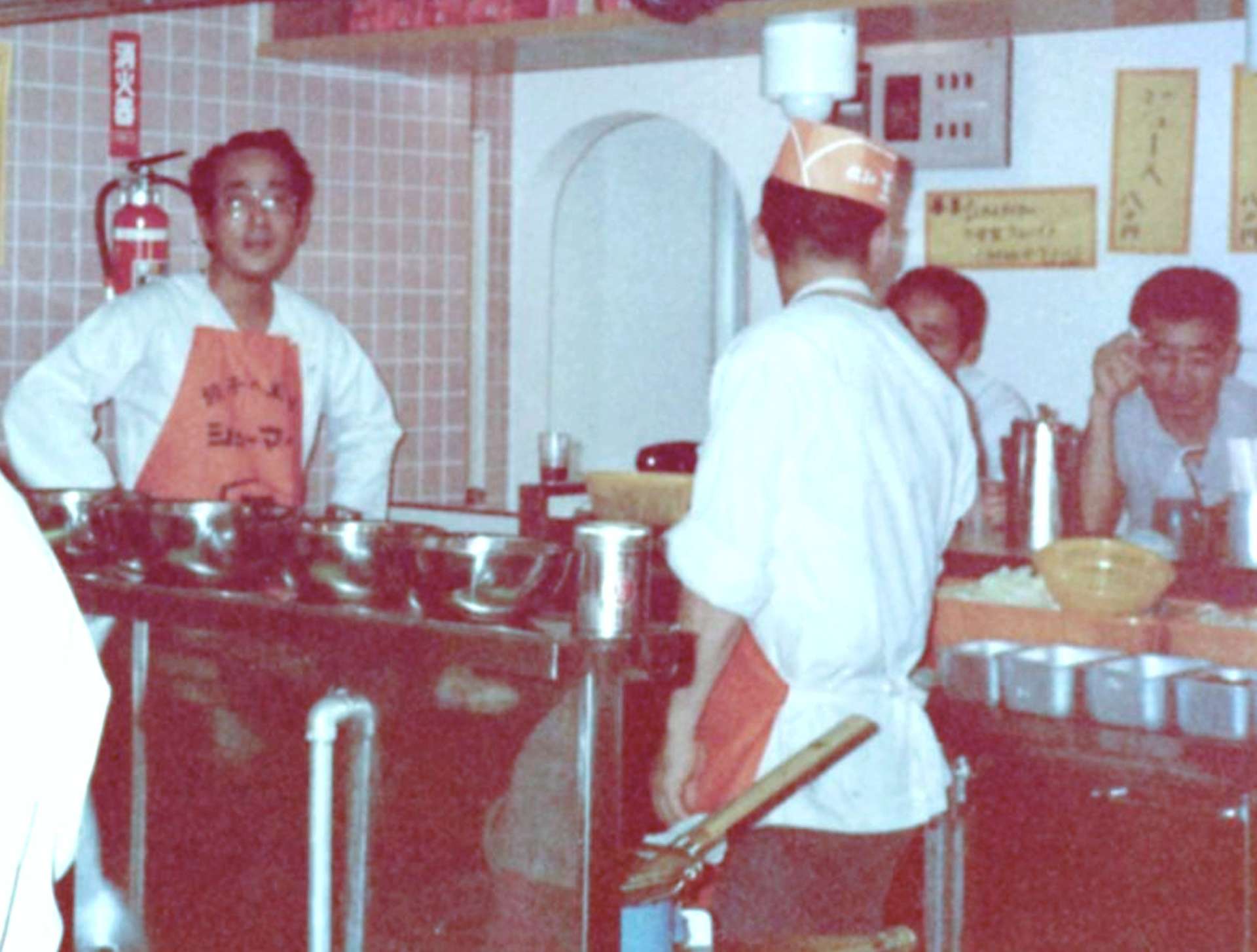 鹿児島餃子の王将のオープン初日に店を手伝う稲盛和夫さん（左）＝１９７８（昭和５３）年、鹿児島市中町（稲盛実さん提供）