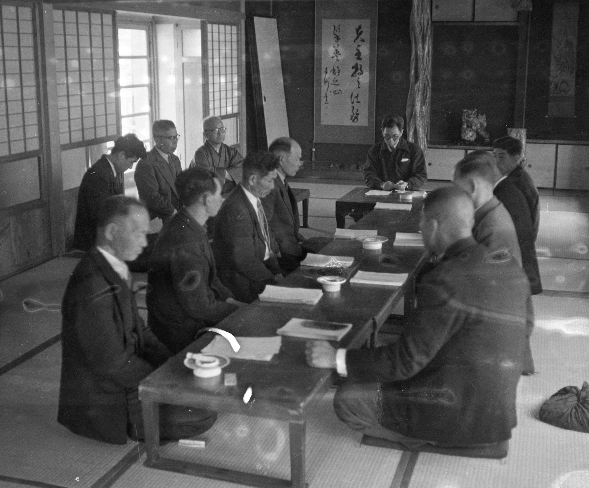三島村の村議会。村長宅が議場となり、畳敷きの部屋で真剣に討議する村議たち＝１９５５（昭和３０）年３月１９日、鹿児島市長田町の安永村長宅