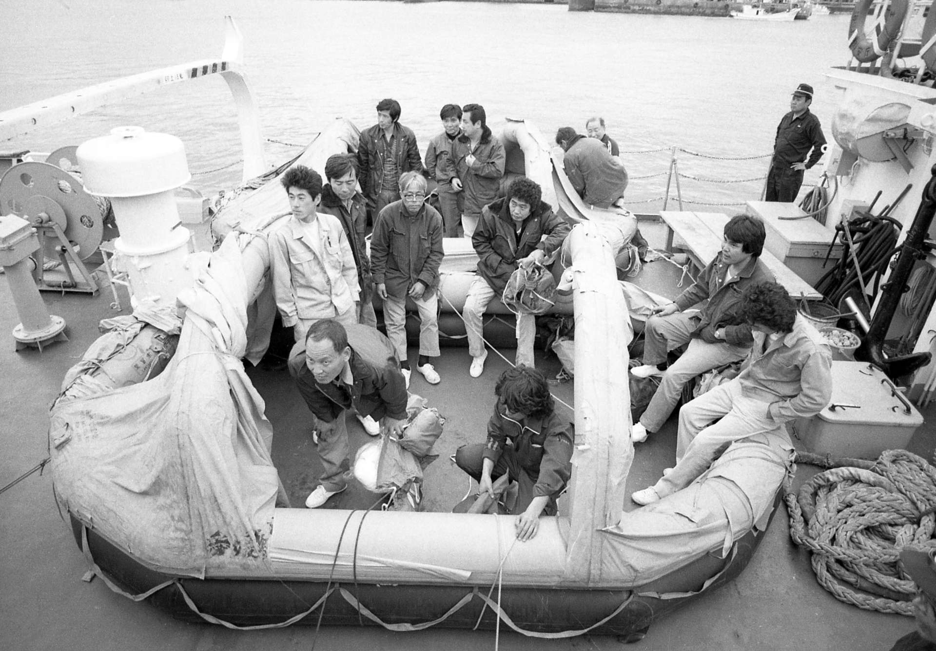 ゴムボートから離れようともせず、おさまらぬ胸のうちをぶちまける１３人の乗組員＝１９８１（昭和５６）年４月１０日、串木野港に着いた巡視船「かみしま」