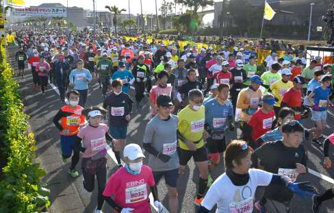 菜の花が咲くコースを一斉にスタートするランナー＝８日、指宿市東方