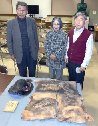 戊辰戦争や西南戦争に従軍した佐土原才助の遺品を寄贈する子孫の山下京子さん（中央）。遺品は（左上から時計回りに）陣がさ、陣羽織、獄中日記＝鹿児島市の西郷南洲顕彰館