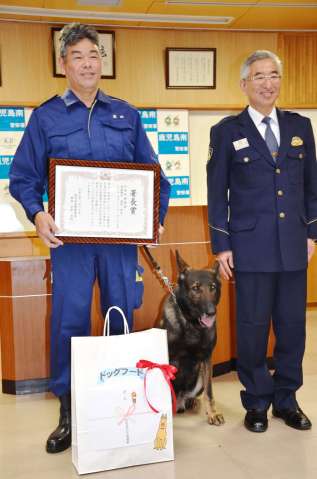 表彰を受けた県警警察犬係長の福留明光さん（左）と警察犬ドリル＝２７日、鹿児島市東開町の鹿児島南警察署
