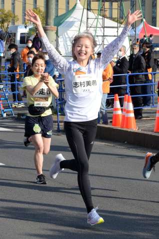 笑顔でファンランを走る志村美希さん（中央）＝５日、鹿児島市本港新町