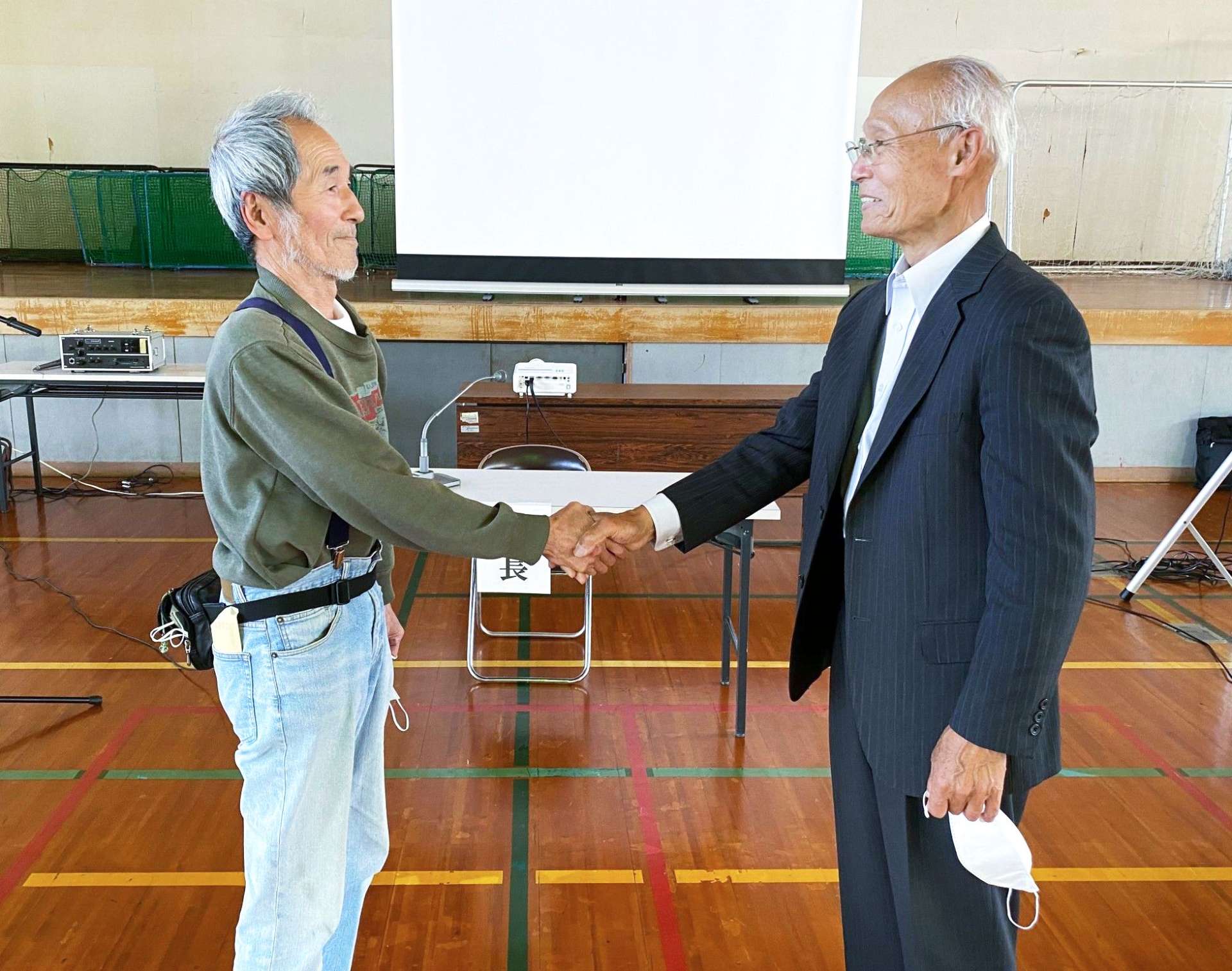 「枦山自治会」設立総会で握手をする旧枦山上、下の両自治会長＝姶良市（枦山自治会提供）