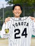 ２０２１年１０月、母校のグラウンドで阪神時代のユニホームを持つ横田慎太郎さん