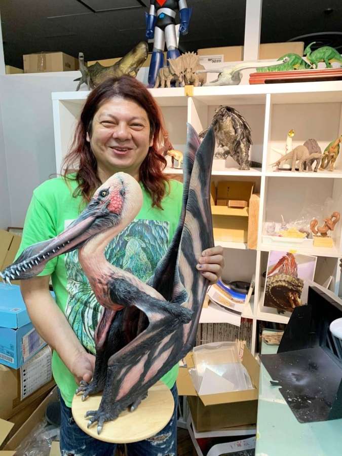 薩摩翼竜の復元模型を持つ古田悟郎さん。「人が造らないマイナーな生き物にも光を当てたい」＝大阪府門真市の海洋堂