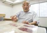 ５０年前の写真を前に当時を振り返る竹之下和雄さん＝４日、東京・新橋