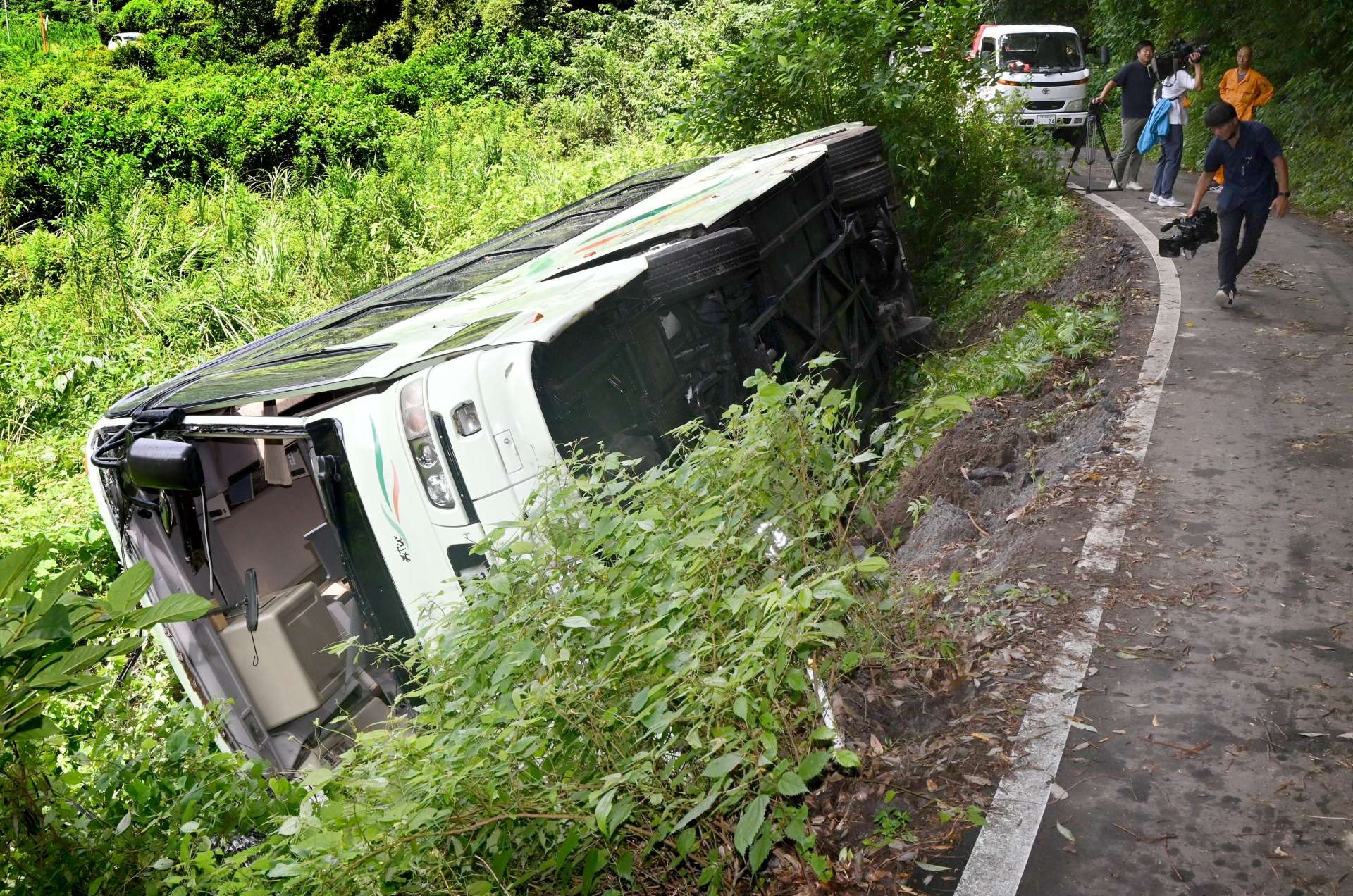 道路脇に転落した観光バス＝１９日午後０時１０分ごろ、鹿児島市春山町