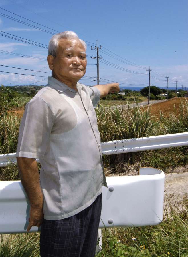 和泊の空襲を眺めていた高台に立つ大福謙蔵さん。海まで見渡すことができ、沖で特攻機が撃墜されるのも目撃した＝和泊町和